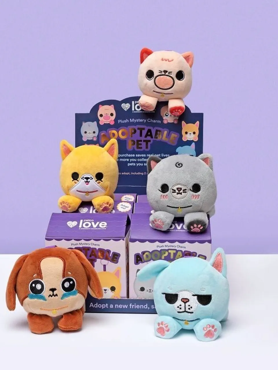 Five colorful plush pet charms displayed with Adoptable Pet boxes.